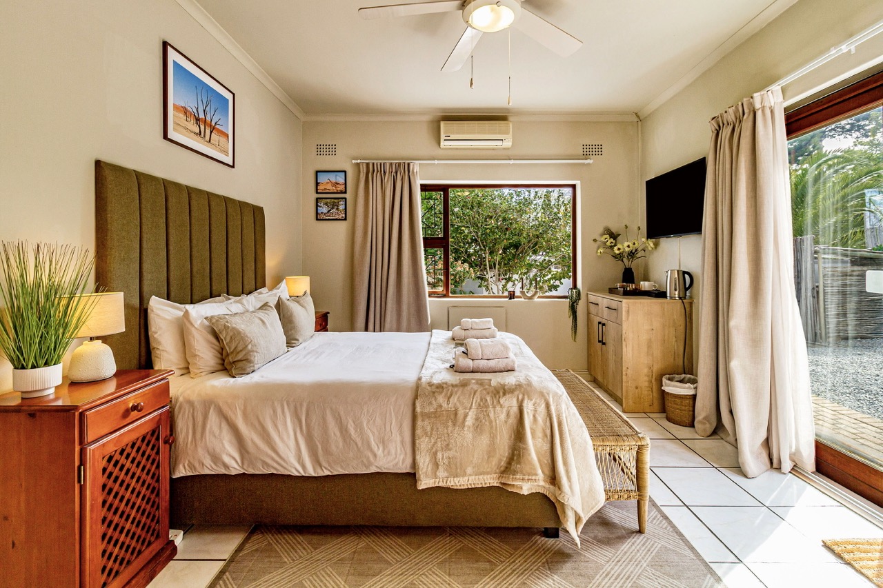 Die African Suite: das Bett mit großem Fenster und Schiebetür zum Garten
