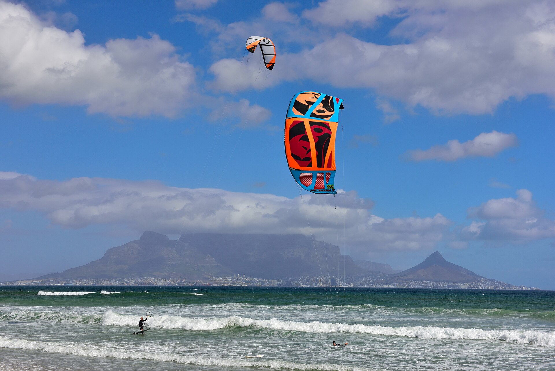 A kitesurfer above the waves at Bloubergstrand with Table Mountain behind
