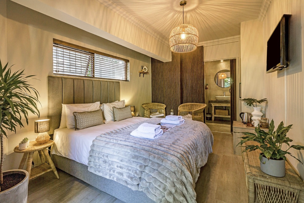 Garden Room 2: a bedroom with a queen bed, a plant and a pendant lamp
