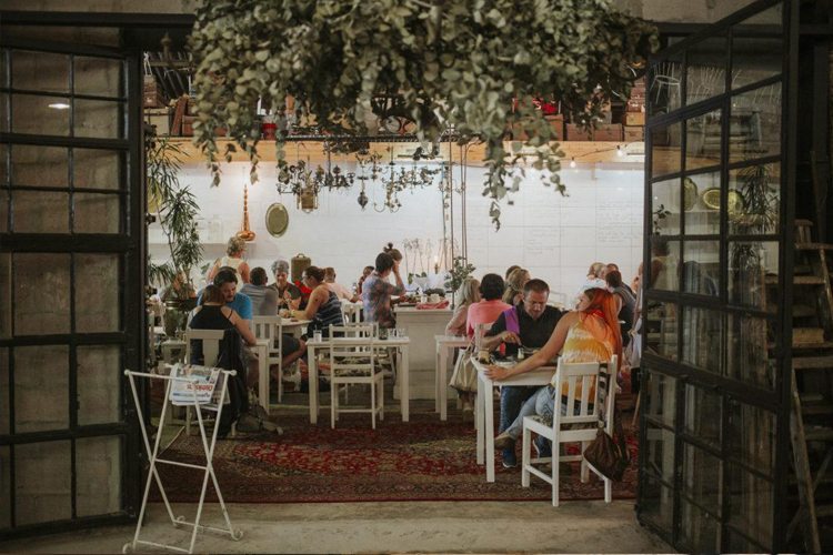 The bright interior of a breakfast cafe with tables and plants