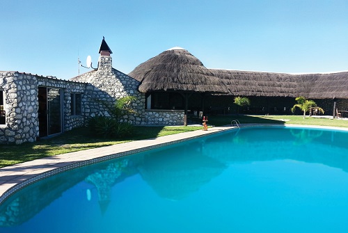 Pool und reetgedeckte Lodge von Buffelsfontein an der Westküste