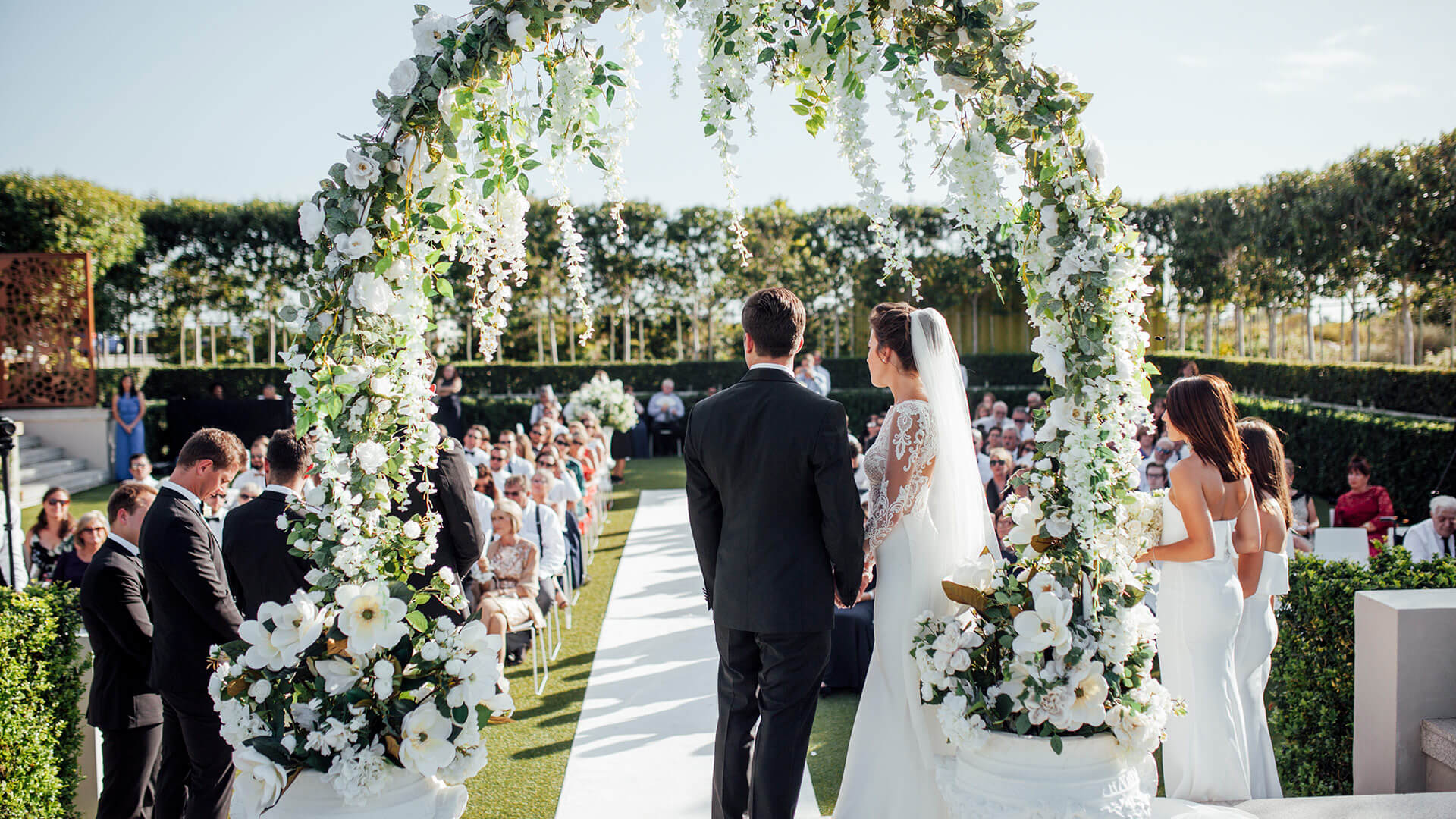 Cape Winelands wedding venues: a ceremony under a floral arch at Cavalli Estate