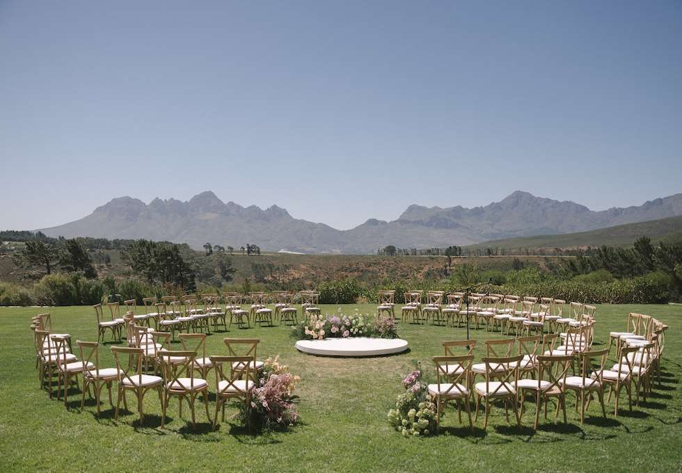 Cape Winelands wedding venues: a ceremony set up on the lawn at Idiom with mountain views